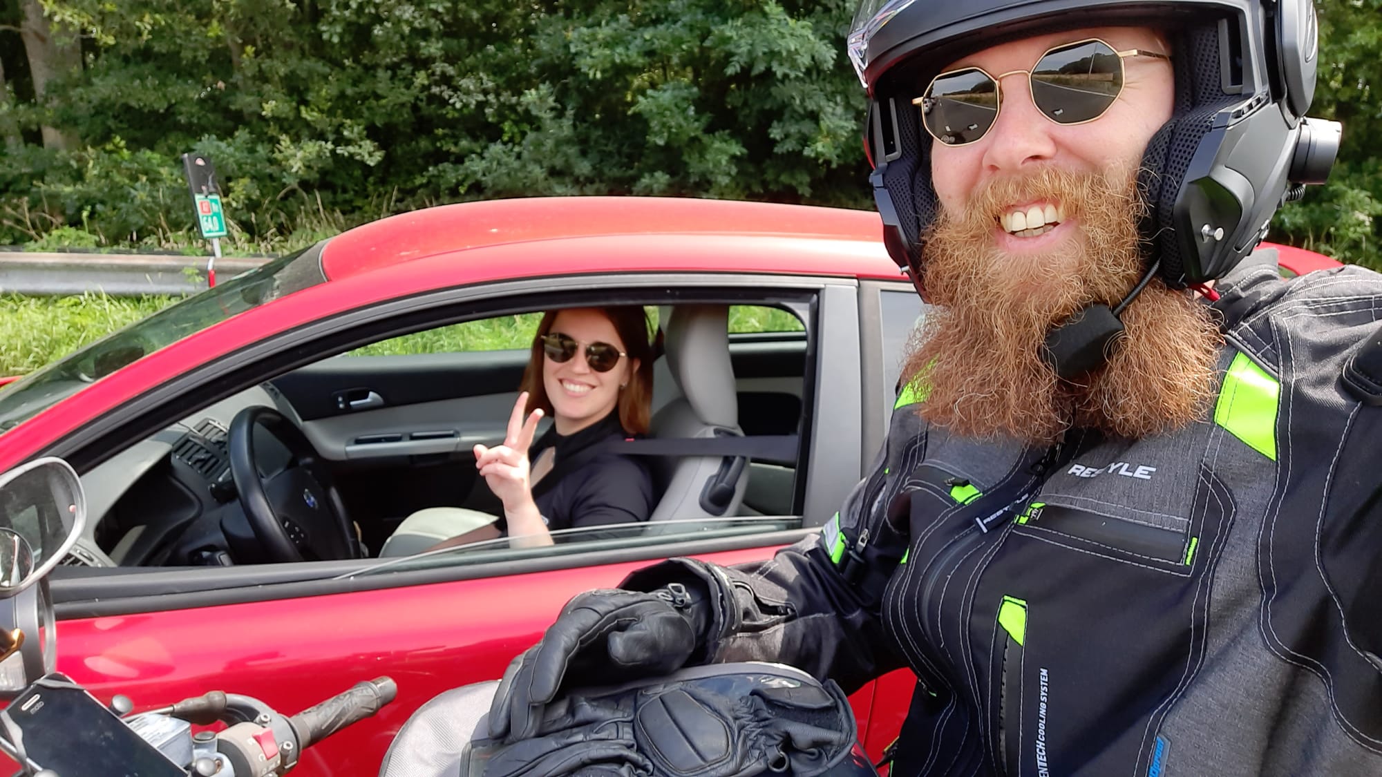 Selfie vanaf de motor, met de auto op de achtergrond